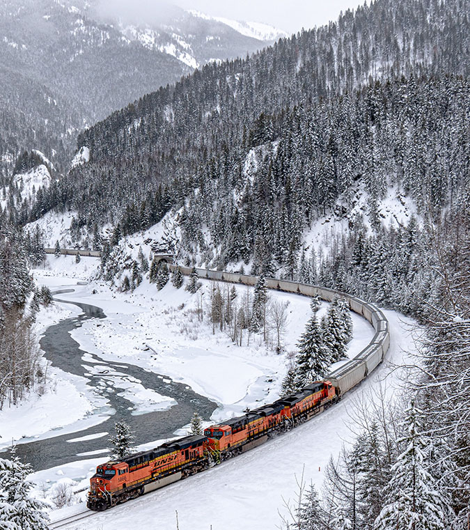 BNSF train passing through Glacier National Park during winter weather