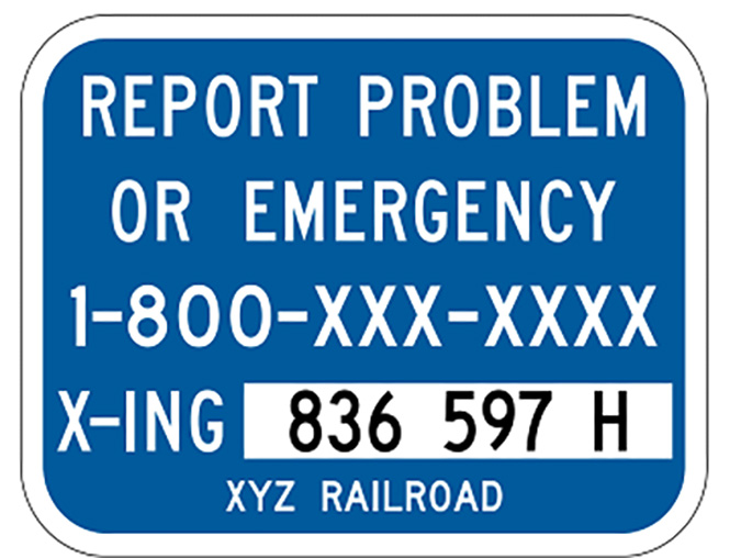 The blue ENS sign has the crossing number and railroad phone number. The blue ENS sign has the crossing number and railroad phone number.